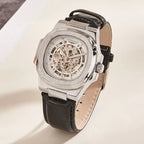 Silver watch with black leather strap on a light background